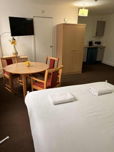 a room with a bed and a table and a kitchen at Budget Studio - Central Gosport with Free Parking in Gosport