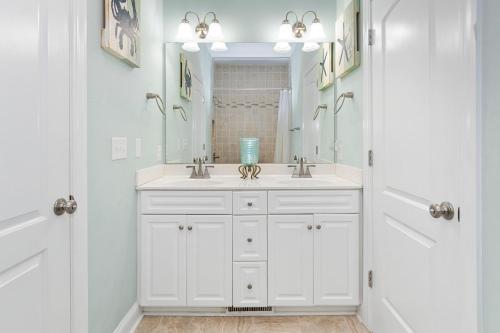 a white bathroom with a sink and a mirror at Sea La Vie in Indian Beach