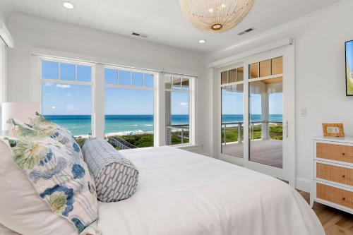 a bedroom with a bed with a view of the ocean at Roosevelt Oceanfront Escape by Emerald Isle Realty in Pine Knoll Shores