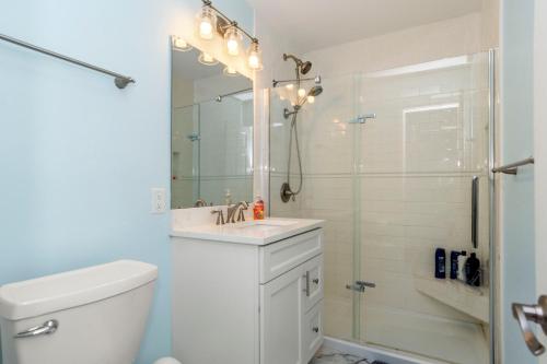 a white bathroom with a sink and a shower at Pine Knoll Townes 126 by Emerald Isle Realty in Pine Knoll Shores