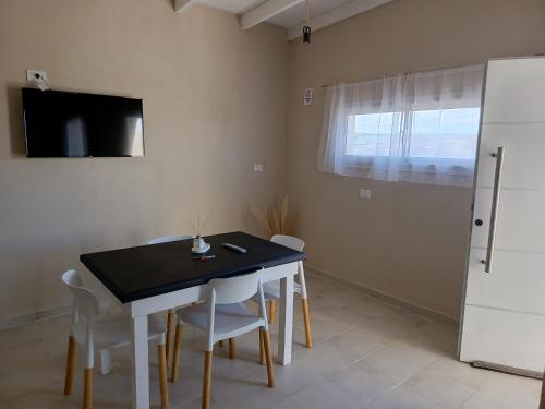 ビージャ・レヒナにあるApart Los Laureles departamento 2のダイニングルーム(黒いテーブル、白い椅子付)