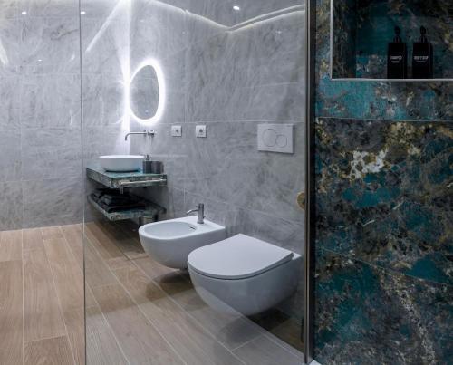 a bathroom with a toilet and a sink and a shower at Casetta 48 in Lido di Ostia