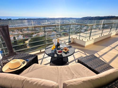 a balcony with a couch and a table with drinks on it at Serenity by the Ocean Penthouse by BeCherish in Páteo