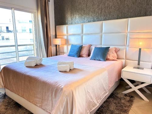 a bedroom with a large bed with two pillows on it at Serenity by the Ocean Penthouse by BeCherish in Páteo