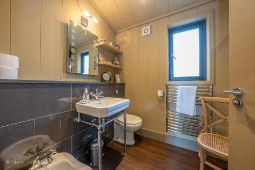 a bathroom with a sink and a toilet and a mirror at Aberdaron-Lodge in Aberdaron
