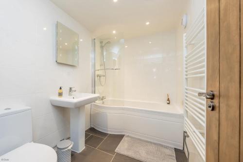a white bathroom with a sink and a tub and a toilet at Gorlan-Llangwnadl in Llangwnadl