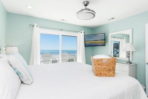 a bedroom with a bed with a view of the ocean at All About Bubbles in Indian Beach