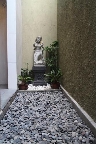 a stone walkway with a statue in a building at Betutu Bali Villas in Ubud