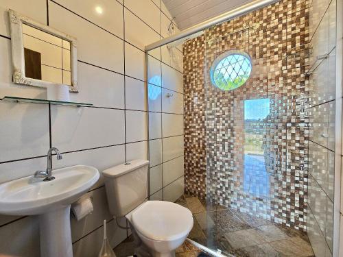a bathroom with a toilet and a sink and a shower at Chalés Pão Sobre as Águas - a 5 minutos de cachoeiras e vista maravilhosa do pôr do sol in Carrancas