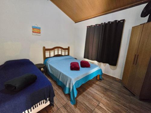 a bedroom with two twin beds and a window at Chalés Pão Sobre as Águas - a 5 minutos de cachoeiras e vista maravilhosa do pôr do sol in Carrancas