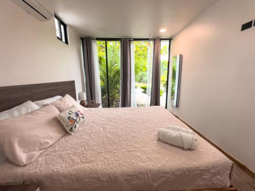 a bedroom with a large bed with a large window at Villa El Bosque Dorado in Fortuna