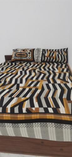a bed with a black and white comforter at Nethu beach villa in Trincomalee