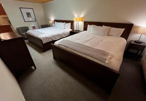 a hotel room with two beds and two lamps at Dove Creek Inn in Dove Creek