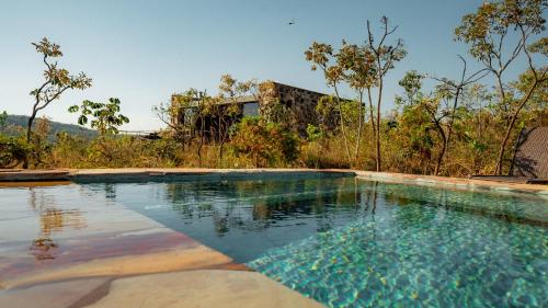 an empty swimming pool in front of a house at Baguá Bangalôs in Sao Jorge