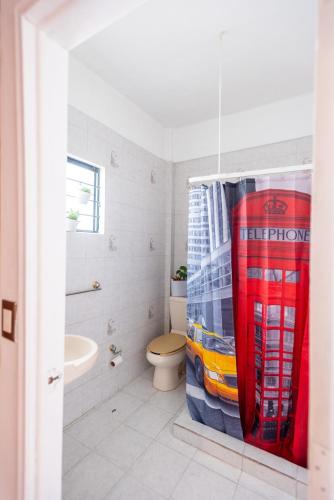 a bathroom with a toilet and a shower curtain at Experience the Magic of the Historic Center from Your Own Balcony in Mexico City