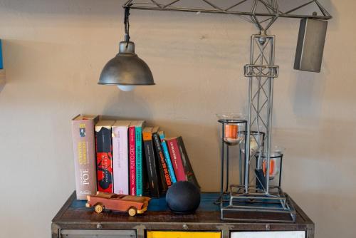 a shelf with books on a table with a lamp at Experience the Magic of the Historic Center from Your Own Balcony in Mexico City