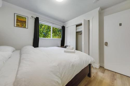a bedroom with a large white bed with a window at Cool & Private 3BR 3BA Near Airport Strong AC in Richmond