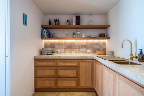 eine Küche mit Holzschränken und einer Spüle in der Unterkunft Onetangi Estate by Waiheke Pure in Waiheke Island