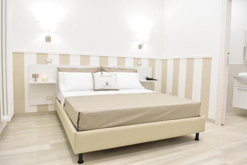 a white bedroom with a bed and a sink at Finestre sul Borgo in Cassano delle Murge