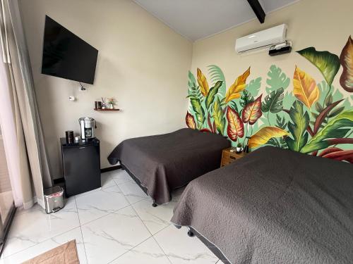 1 dormitorio con 2 camas y un mural de plantas en Villa ViVe, en Florencia