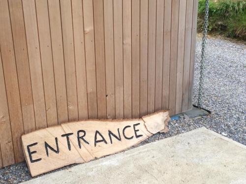 a sign that reads entrance leaning against a fence at Blackstairs Shepherds Huts in Killedmond