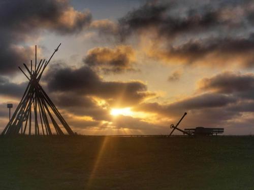 a windmill and a bench in front of a sunset at 6 person holiday home in Tarm-By Traum in Tarm