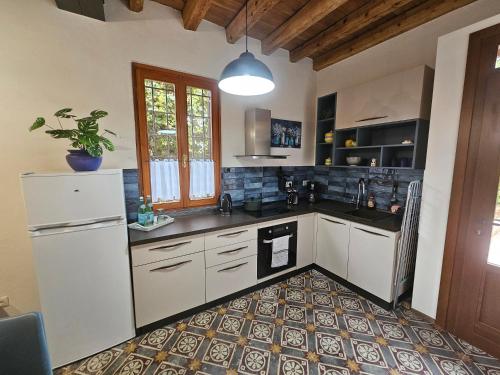 une cuisine avec des appareils blancs et une plante en pot dans l'établissement Residence Katrins, à San Giorgio in Salici