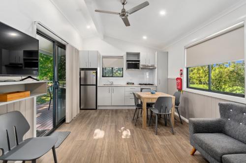 a kitchen and living room with a table and a couch at Mittagong Holiday Park in Mittagong