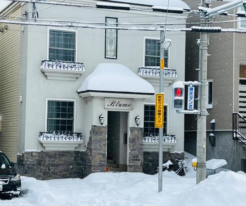 a house with snow on the front of it at Blume 中央区温馨小屋 地铁西18丁目站步行10分钟 in Sapporo