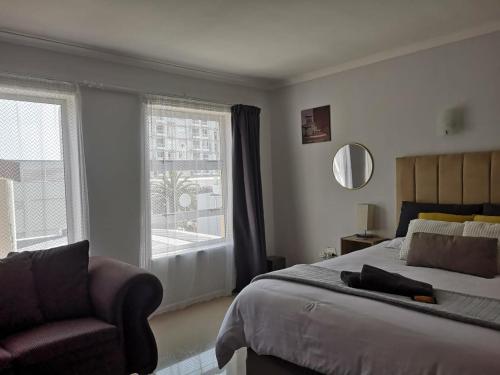 a bedroom with a bed and a chair and a window at Relaxing Hideaway in Strand