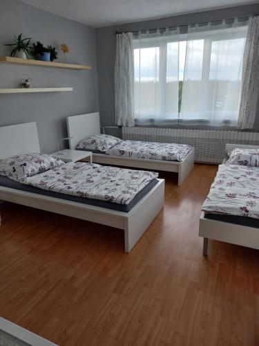 Un dormitorio con tres camas y una ventana. en Paradise villa apartment, en Praga