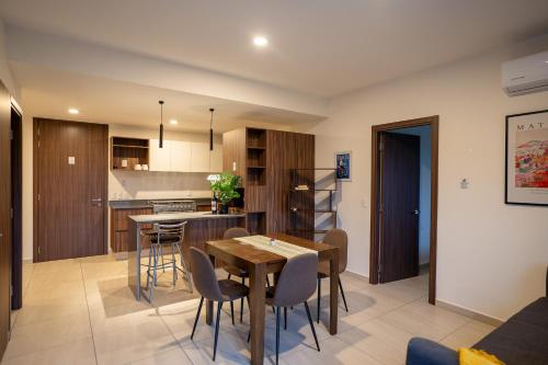 a kitchen and dining room with a table and chairs at Departamento 2 Recamaras en Torre Anuva con Alberca y Gym in Guadalajara
