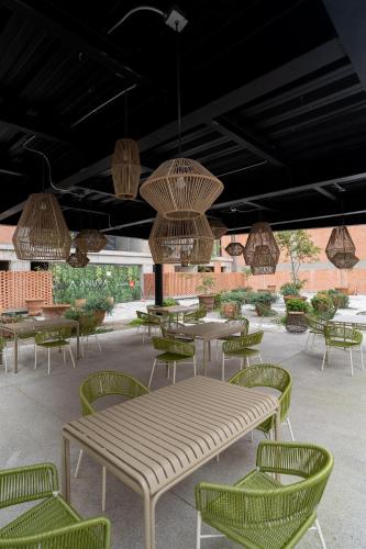 a patio with tables and chairs and chandeliers at Departamento 2 Recamaras en Torre Anuva con Alberca y Gym in Guadalajara