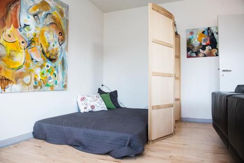 JellingにあるMølvangvej 2 Jelling Apartmentのベッドルーム1室(ベッド1台付)が備わります。壁には絵画が飾られています。