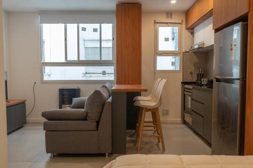 マル・デル・プラタにあるLoft amplio y moderno a 2 cuadras del mar calidad superiorのキッチン(ソファ、椅子付)