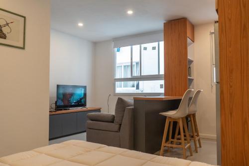 マル・デル・プラタにあるLoft amplio y moderno a 2 cuadras del mar calidad superiorのリビングルーム(ソファ、椅子、テレビ付)
