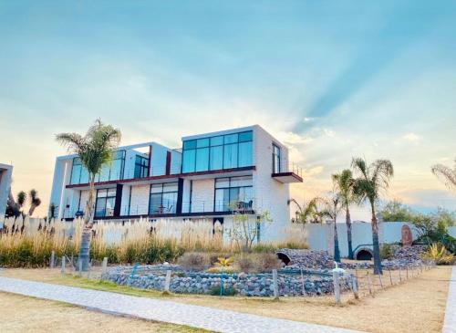 a building with palm trees in front of it at Casa Diamante Hotel Boutique - Mineral de Pozos in Mineral de Pozos