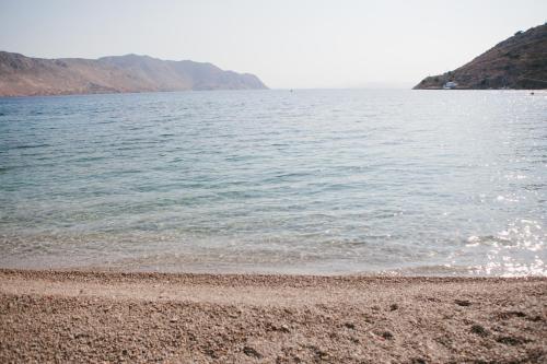 a beach with a large body of water at Niriides Hotel Apartments in Symi