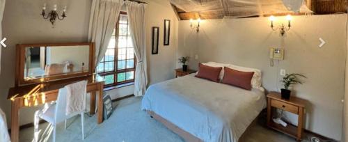 a bedroom with a bed and a desk and a mirror at Dee in Sandton
