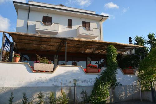 een wit huis met potplanten erop bij B&B Collemare in Drapia