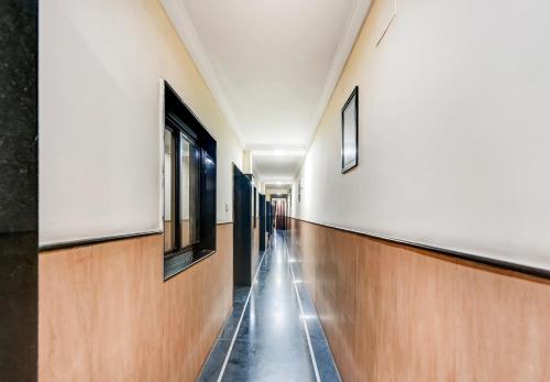 an empty hallway in a building with wooden floors and windows at Hotel O Rourkela Palace in Raghunāthpāli