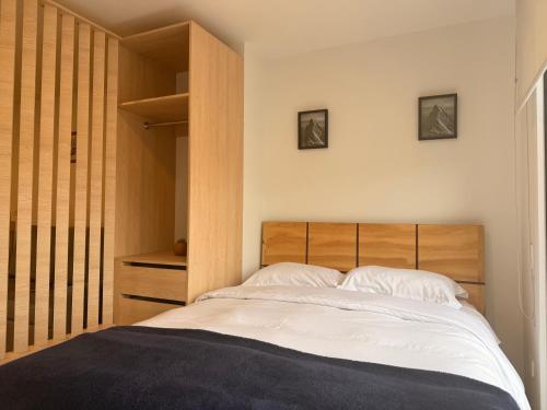 a bedroom with a bed and a wooden headboard at Moderno Loft Urbano con Balcón in Sogamoso