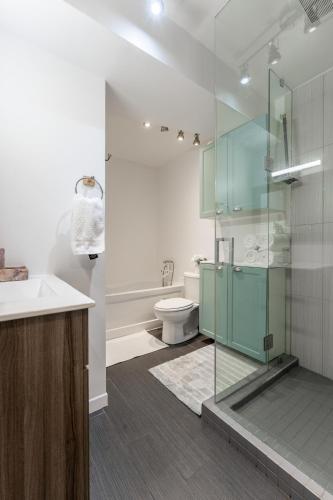 a bathroom with a glass shower and a toilet at Cozy Family Home Near Montreal in Brossard