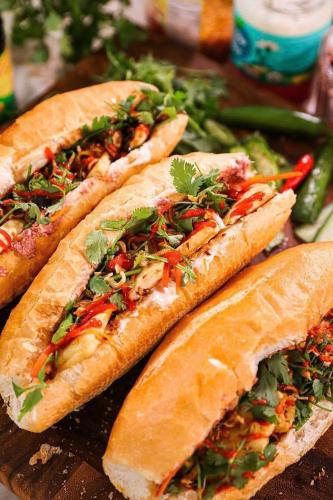 吉婆岛CATBA PANDORA Hotel & Travel的桌子上摆着三份蔬菜三明治。