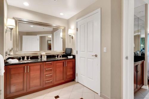 a bathroom with a large mirror and a sink at Mgm 1 Bedroom Balcony And Or Studio Luxury Suites in Las Vegas