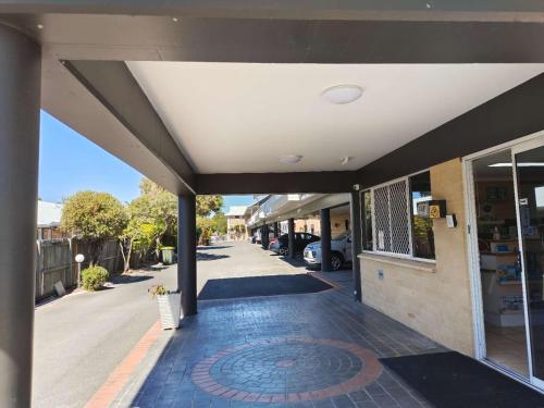 a front entrance to a building with a driveway at Best Western Ambassador Motor Lodge in Hervey Bay