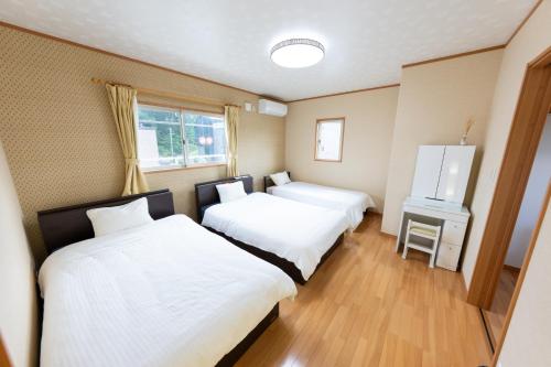 a room with two beds and a window at GuestHouse　YOU&I in Fujikawaguchiko