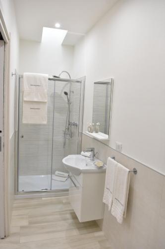 a white bathroom with a shower and a sink at Finestre sul Borgo in Cassano delle Murge