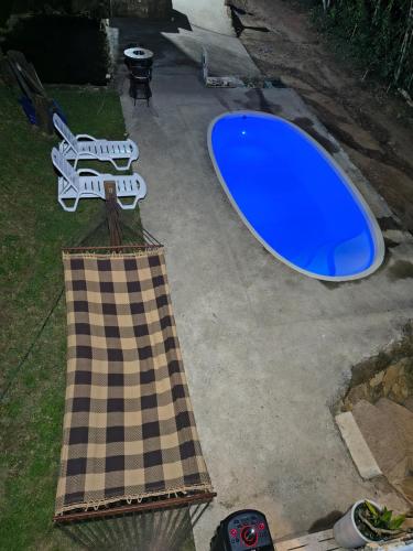 a blue surfboard sitting on the ground next to a table at Chalé Foroni in Cunha