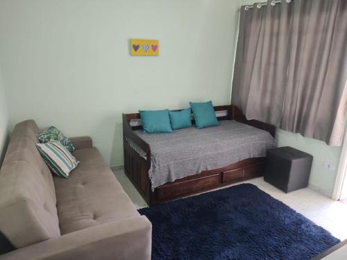 a living room with a couch and a bed at Casa bem localizada in Guarujá